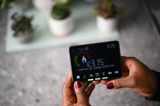 (FILES) A smart meter indicating how many kWh (kilowatt-hour) of energy has been used already in one day, and how much it has cost in pounds sterling, is pictured in a house in London, on December 13, 2022. The price cap on energy bills for most UK households will rise this winter, regulator Ofgem said on November 23, 2023, further fuelling a cost-of-living crisis that is forecast to worsen. Bills will climb from January on rising wholesale energy prices, which have increased due to key producer Russia's war in Ukraine, Ofgem said in a statement. (Photo by Daniel LEAL / AFP) (Photo by DANIEL LEAL/AFP via Getty Images)