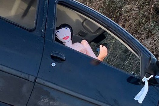 A blow up doll has been placed inside an abandoned car crashed at a junction on Mill Land in Swindon, Wilts., in prank locals have found amusing. Release date January 31 2025. Locals have been left amused after a blow-up doll was spotted inside an abandoned car that had crashed into a ditch. The aftermath of the crash, on Mill Lane in Swindon, Wilts, saw a car after the driver allegedly fled - and a blow-up doll placed in the empty seat. Photos of the scene were shared online. Casey Waren-Keel was one of the members of the public who spotted the doll and found it amusing - sharing a snap on the Swindon Community Notice Board.