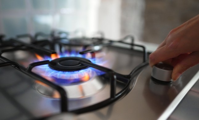 Woman turning on the gas burner on the stove.; Shutterstock ID 2277294059; purchase_order: -; job: -; client: -; other: - 13619187