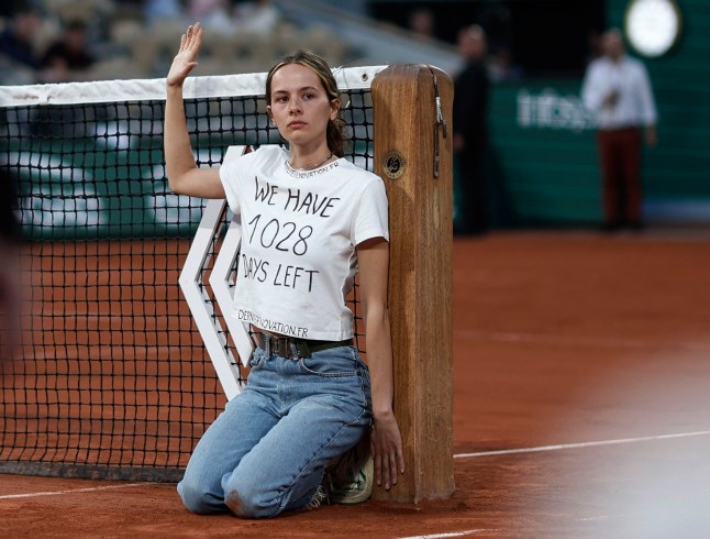Tennis - French Open - Roland Garros, Paris, France - June 3, 2022 Protestor ties herself to the net during the semi final between Norway's Casper Ruud and Croatia's Marin Cilic REUTERS/Benoit Tessier
