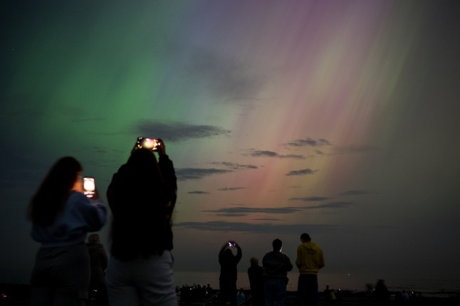 WHITLEY BAY, ENGLAND - MAY 10: People visit St Mary's lighthouse in Whitley Bay to see the aurora borealis, commonly known as the northern lights, on May 10, 2024 in Whitley Bay, England. The UK met office said a strong solar storm may allow northern parts of the UK the chance to see displays of aurora. (Photo by Ian Forsyth/Getty Images)