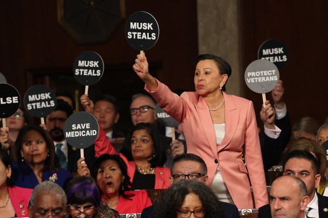 US Representative Nydia Vel??zquez (D-NY) holds a "Musk Steals" protest sign with fellow Democrats as US President Donald Trump speaks during an address to a joint session of Congress at the US Capitol in Washington, DC, on March 4, 2025. (Photo by Win McNamee / POOL / AFP) (Photo by WIN MCNAMEE/POOL/AFP via Getty Images)