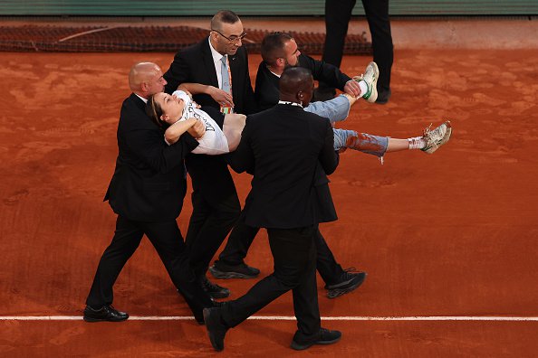 PARIS, FRANCE - JUNE 03: A protester is carried off the court after tying themselves to the net during the Men's Singles Semi Final match between Marin Cilic of Croatia and Casper Ruud of Norway on Day 13 of The 2022 French Open at Roland Garros on June 03, 2022 in Paris, France. (Photo by Clive Brunskill/Getty Images)