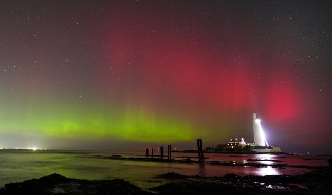 The sky is filled with colour from the aurora borealis, also known as the Northern Lights, at St Mary's lighthouse in Whitley Bay on the North East coast of England. Picture date: Wednesday March 26, 2025. PA Photo. Photo credit should read: Owen Humphreys/PA Wire