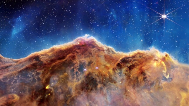A jaw-dropping new visualisation shows dramatic 'cosmic cliffs' in space. Space scientists have released a new exploration of a star-forming region captured by NASA???s James Webb Space Telescope. It features part of the Carina Nebula Complex, which is located about 50 quadrillion miles from Earth. NASA Webb Mission Team said: "The landscape of ???mountains??? and ???valleys??? known as the Cosmic Cliffs is actually a portion of the nebula Gum 31, which contains a young star cluster called NGC 3324."