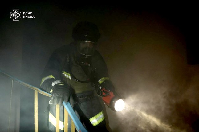 This handout photograph taken and released by the Ukrainian State Emergency Service press service on May 24, 2025, shows a firefighter advancing in a cloud of smoke during a blaze in a residential building following Russian strike in Kyiv, amid Russian invasion in Ukraine. At least eight people were wounded in a drone and missile attack on Kyiv on May 24, 2025, city authorities said, just as Russia and Ukraine were in the middle of a major prisoner swap. The head of Kyiv's civil and military administration, Tymur Tkachenko, reported fires and fallen debris in several parts of the Ukrainian capital, after AFP journalists heard explosions overnight. (Photo by Handout / Ukrainian State Emergency Service Press Service / AFP) / RESTRICTED TO EDITORIAL USE - MANDATORY CREDIT "AFP PHOTO / Ukrainian State Emergency Service press service" - HANDOUT - NO MARKETING NO ADVERTISING CAMPAIGNS - DISTRIBUTED AS A SERVICE TO CLIENTS (Photo by HANDOUT/Ukrainian State Emergency Service Press Service/AFP via Getty Images)