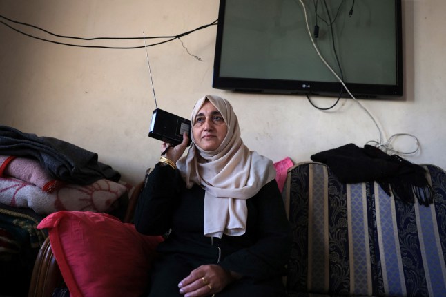 A Palestinian woman listens to radio in her house in Rafah in the southern Gaza Strip on December 19, 2023, amid continuing battles between Israel and the militant group Hamas. (Photo by SAID KHATIB / AFP) (Photo by SAID KHATIB/AFP via Getty Images)