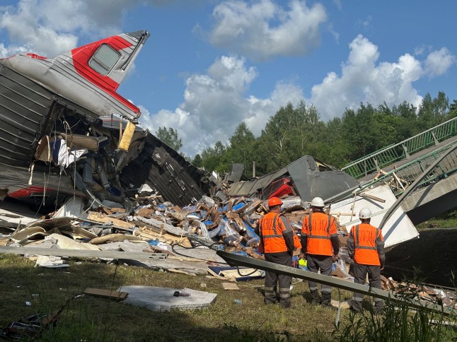 Specialists of emergency services work at the scene, after a road bridge collapsed onto railway tracks due to an explosion in the Bryansk region, Russia, June 1, 2025. REUTERS/Stringer