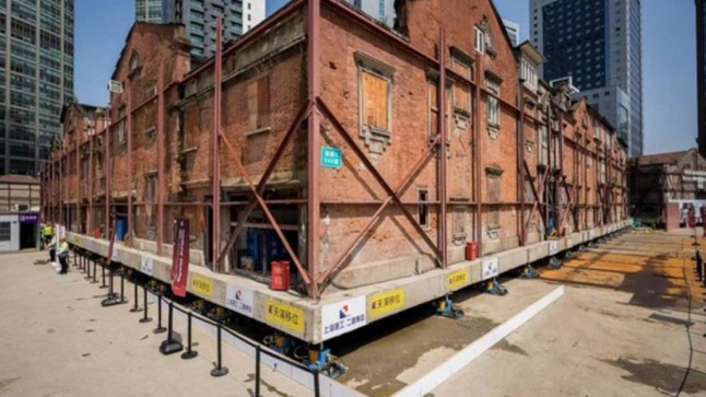 Story from Jam Press (Robots Move Building) Pictured: The 7,400-tonne building being moved by tiny robots. VIDEO: Hundreds of tiny ROBOTS move 7,400 tonne building complex Hundreds of tiny, self-walking robots are moving a 7,400 tonne building complex. The relocation has been described as one of the largest and most complex neighbourhood transfers to date. A total of 432 hydraulic-powered robots are being used to walk the gigantic structure 10 meters a day. In a sped up video of the project, posted on Tuesday (10 June), the complex can be seen shifting in different directions, as reported by NeedToKnow. The minute robots, which are sat underneath the structure, are capable of navigating corridors less than 1.2 meters wide. They have been programmed to distinguish between clay and solid obstacles which prevents damage during excavation. Once the area beneath the buildings was cleared and reinforced, the entire complex was hoisted onto a steel frame and placed on top of the fleet of walking robots. Built in the 1920s and 1930s, the complex?s narrow alleys and tightly packed layout made traditional relocation machinery not particularly useful. For this reason, engineers turned to cutting-edge technology and decided to use a blend of 3D modeling, deep-learning AI, and precision robotics. Each robot is remote-controlled, and designed specifically for this type of work. In total, the Huayanli complex, located in the Zhangyuan, an area in the Jing'an District of Shanghai, measured 13,222 square-foot. The project, which began on 19 May, is part of a large development plan to construct a three-story underground structure beneath the site. Eventually, the building will be returned to its original location once underground construction is complete. The finished underground space will include cultural venues, commercial zones, and over 100 new parking spots. It will also be integrated into Shanghai?s subway lines 2, 12, and 13. ENDS EDITOR'S NOTE: Video Usage Licence:(PROFESSIONAL PARTNER) We have obtained this material from a professional partner for use by our news media clients (company press release / other media agency). Video Restrictions: None.