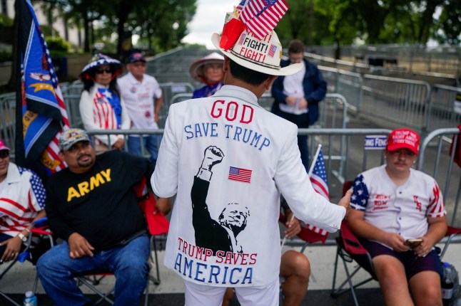A supporter of U.S. President Donald Trump wears a hat with U.S. flags on the day of a military parade to commemorate the U.S. Army's 250th Birthday in Washington, D.C., U.S., June 14, 2025. REUTERS/Nathan Howard
