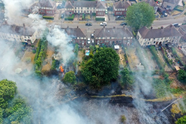 SHEFFIELD, ENGLAND - JULY 20: In this aerial view Firefighters contain a wildfire that encroached on nearby homes in the Shiregreen area of Sheffield on July 20, 2022 in Sheffield, England. Multiple fires have broke out across the UK yesterday and today as the UK experienced a record-breaking heatwave. Temperatures in many places reached 40c and over. (Photo by Christopher Furlong/Getty Images)