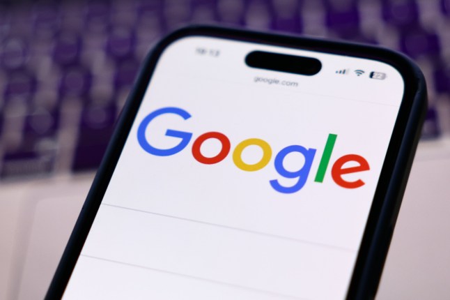 A laptop keyboard and Google website displayed on a phone screen are seen in this illustration photo taken in Krakow, Poland on March 12, 2025. (Photo by Jakub Porzycki/NurPhoto via Getty Images)