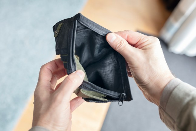 Empty wallet or purse in poor mans hands. Poverty, money shortage, bankrupt or financial crisis