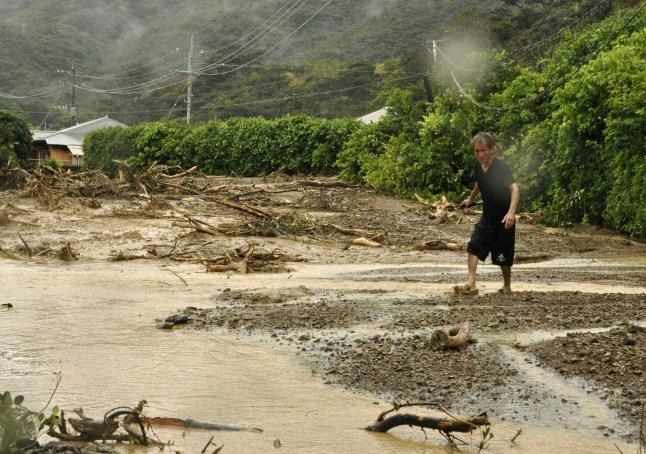 apan - A man walks on a road turned to mud by a downpour in the town of Tatsugo on Amami Island, Kagoshima Prefecture, southwestern Japan, on Sept. 26, 2011. (Kyodo)