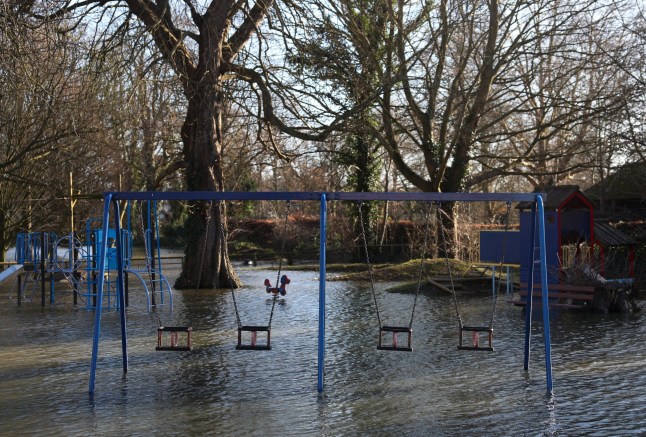 Floodwater surrounds swings and play equipment in a flooded children's park in Wraysbury, west of London on January 9, 2024, after heavy rain brought flooding to much of the country following Storm Henk. (Photo by Daniel LEAL / AFP) (Photo by DANIEL LEAL/AFP via Getty Images)