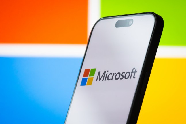 CHONGQING, CHINA - APRIL 26: In this photo illustration, the logo of Microsoft Corporation is displayed on a smartphone screen, with the company's colorful branding visible in the background, on April 26, 2025, in Chongqing, China. Microsoft is a leading American multinational technology company, known for its Windows operating system, Microsoft Office software suite, Azure cloud services, and other enterprise and consumer technology products. (Photo illustration by Cheng Xin/Getty Images)