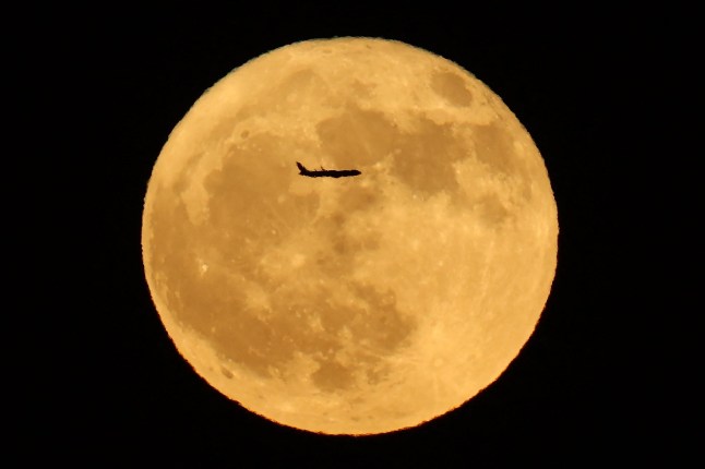 The silhouette of a plane crosses the full Buck Moon in Adelanto, California, on July 10, 2025. (Photo by Patrick T. Fallon / AFP) (Photo by PATRICK T. FALLON/AFP via Getty Images)
