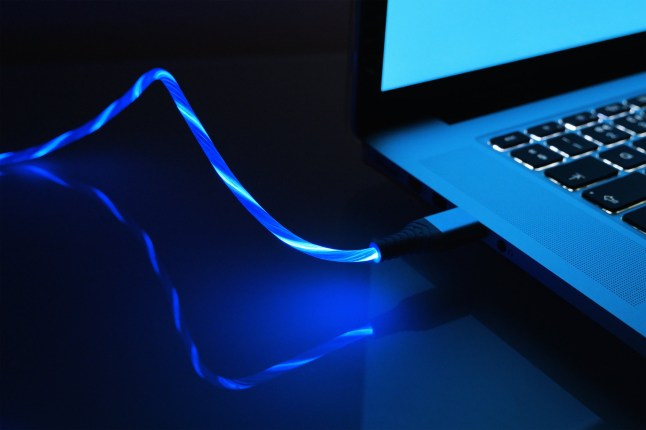 Close up of Laptop Computer with data cable. Illustration of fast data transfer, streaming download and connectivity.