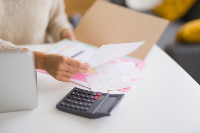 Unrecognizable woman calculating domestic bills and invoices at home