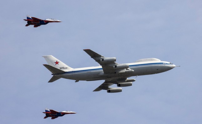 A Russian Il-80 military transport aircraft, also known as the Doomsday plane, and MiG-29 fighter jets escorting it seen at a military parade.