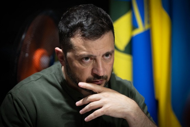 In this handout photograph taken and released by the Ukrainian Presidential Press Service on August 4, 2025, Ukraine's President Volodymyr Zelensky looks on as he meets with soldiers of the 57th Separate Motorised Infantry Brigade on the frontline positions at an undisclosed location in the Kharkiv region, amid the Russian invasion of Ukraine. President Volodymyr Zelensky said on August 4, 2025 that he had visited Ukrainian troops holding the line in the Kharkiv region bordering Russia and discussed how drones were used in fighting. (Photo by Handout / UKRAINIAN PRESIDENTIAL PRESS SERVICE / AFP) / RESTRICTED TO EDITORIAL USE - MANDATORY CREDIT "AFP PHOTO / UKRAINIAN PRESIDENTIAL PRESS SERVICE" - NO MARKETING NO ADVERTISING CAMPAIGNS - DISTRIBUTED AS A SERVICE TO CLIENTS (Photo by HANDOUT/UKRAINIAN PRESIDENTIAL PRESS SERVICE/AFP via Getty Images)