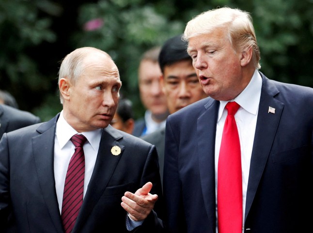 U.S. President Donald Trump and Russia's President Vladimir Putin talk during the family photo session at the APEC Summit in Danang, Vietnam November 11, 2017.