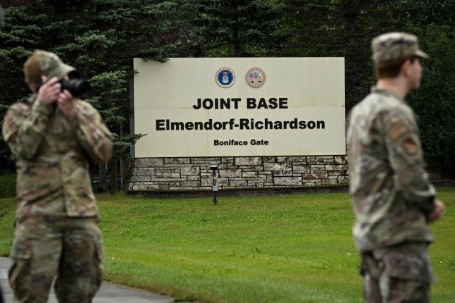 Members of the military stand outside an entrance to Joint Base Elmendorf-Richardson in Anchorage, Alaska, on August 14, 2025, ahead of the August 15 scheduled meeting between US President Donald Trump and Russian President Vladimir Putin. Trump on Thursday acknowledged his high-stakes summit with Vladimir Putin may fail, and said any Ukraine deal would come through a future three-way meeting with Kyiv to "divvy things up." Russian President Vladimir Putin flies to Alaska on Friday at the invitation of Trump in his first visit to a Western country since he ordered the 2022 invasion of Ukraine that has killed tens of thousands of people. (Photo by Drew ANGERER / AFP) (Photo by DREW ANGERER/AFP via Getty Images)