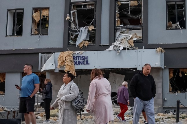 People stand at the site of a building housing the local branch of the British Council after it was hit during Russian missile and drone strikes, amid Russia's attack on Ukraine, in Kyiv, Ukraine, August 28, 2025. REUTERS/Alina Smutko