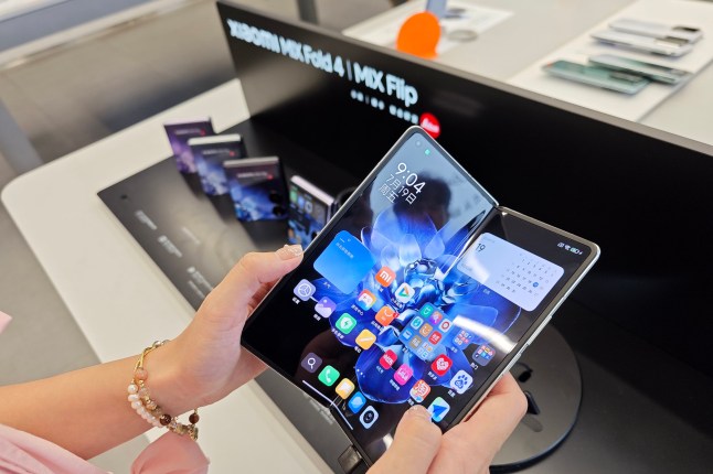 Customers are experiencing the Xiaomi MIX Fold 4 foldable screen phone at a Xiaomi store in Tongling, Anhui province, China, on July 19, 2024.