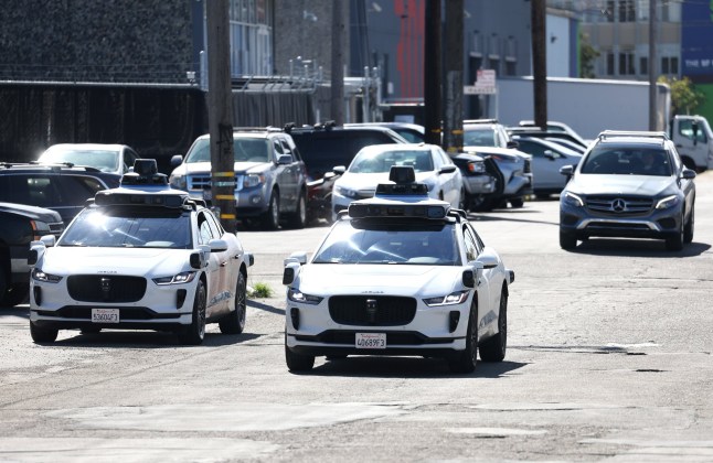 SAN FRANCISCO, CALIFORNIA - MARCH 01: Waymo cars drive down a street on March 01, 2023 in San Francisco, California. Waymo, Alphabet's self-driving car division, announced that it has laid off over 135 employees in a second round of layoffs this year. Waymo has cut 8 percent of its workforce this year. (Photo by Justin Sullivan/Getty Images)