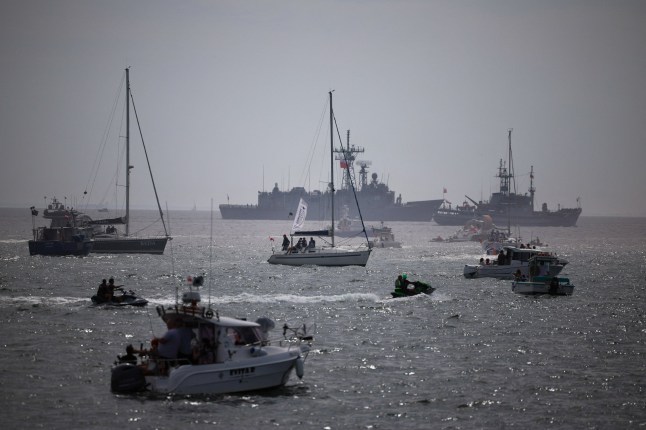 People watch from boats as Polish Navy vessels Multi-task rescue-salvage ship ORP Piast and Guided-missile frigate ORP General Tadeusz Kosciuszko participate in a naval parade on Armed Forces Day, commemorating Poland's victory over the Soviet Red Army in 1920, in Gdansk Bay, Poland, August 15, 2025. REUTERS/Kacper Pempel