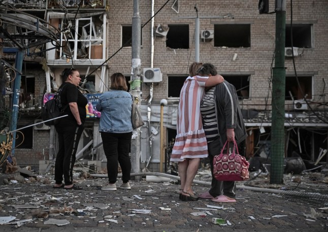 Residents stand at the site of an apartment building hit during a Russian drone and missile strike, amid Russia's attack on Ukraine, in Zaporizhzhia, Ukraine.