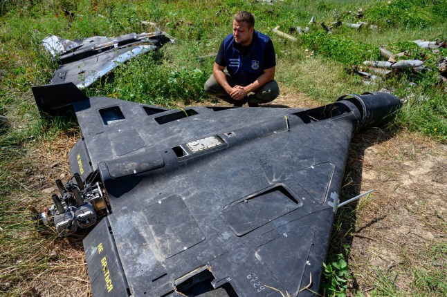 KHARKIV, UKRAINE - JULY 30: Dmytro Chubenko of the Kharkiv regional prosecutor's office examines the carbon fiber remains of a Russian-made, Iran-designed Shahed-136 drone, known as a Geran-2 in Russia, as the prosecutor's office maintains a collection of Russian drones, glide bombs, missiles and rockets launched at Ukraine as evidence for eventual war crimes prosecutions against Russia, on July 30, 2025 in Kharkiv, Ukraine. Russia has intensified missile and drone attacks against Ukraine, firing more than 700 in a single night, often against civilian targets, amidst a surge of daily aerial bombardments of urban centers, 3 1/2 years after Russia's all-out invasion of Ukraine. (Photo by Scott Peterson/Getty Images)