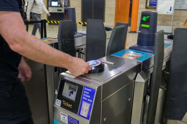 Man using card for getting through ticket barrier