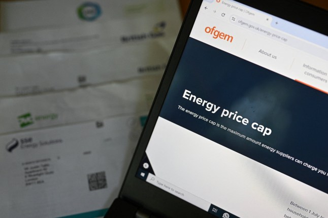 The website of Britain's energy regulator Ofgem, is displayed on the screen of a laptop, next to energy bills on a desk in a residential property in Guildford, south of London on August 21, 2024. (Photo by Justin TALLIS / AFP) (Photo by JUSTIN TALLIS/AFP via Getty Images)