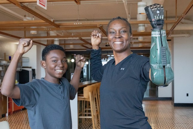 Danielle Green strikes a hero pose with her son after being fitted with the Hero RGD???, the first U.S. veteran to wear the world???s most advanced bionic arm from Open Bionics. Her custom covers, created in partnership with Call of Duty Endowment, debuted at Call of Duty NEXT 2025 event in Las Vegas, September 30. A female US Army vet who nearly died in a grenade attack in Iraq has become the first in the world to be fitted with a new 'hero' bionic arm - inspired by Call of Duty.Danielle Green lost her left arm while serving in Baghdad 20 years ago and has struggled with every day tasks ever since.But now, in a world-first, the 48-year-old says she wants to inspire fellow vets and amputees - and finally feels 'complete' after being fitted with the Hero RGD.The rugged new limb, described as the world's stongest bionic arm, has been developed by UK robotics firm Open Bionics with a design inspired by the Call of Duty: Black Ops 7 game. Photo released 01/10/2025