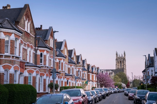 Clapham, London, Lavender Gardens SW11, a row of large brick terrace houses, Victorian style 19th Century architecture, copy space with clear blue sky, church tower in the distance, no people