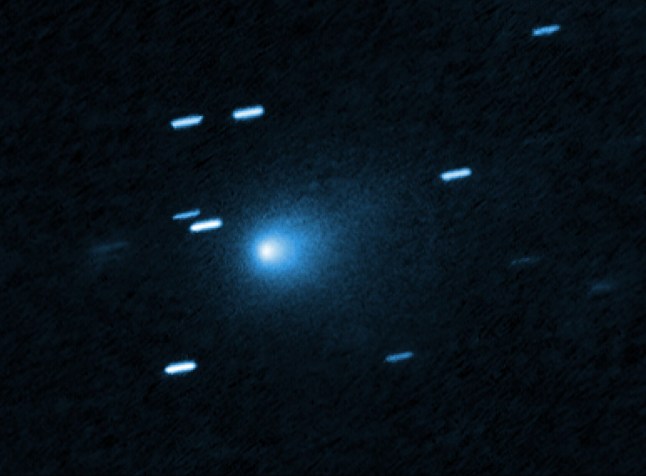 This is a Hubble Space telescope image of the interstellar comet 3I/ATLAS. Hubble photographed the comet on 21 July 21 2025, when the comet was 445 million kilometres from Earth. Hubble shows that the comet has a teardrop-shaped cocoon of dust coming off its solid, icy nucleus. Because Hubble was tracking the comet moving along a hyperbolic trajectory, the stationary background stars are streaked in the exposure. [Image description: At the center of the image is a comet that appears as a teardrop-shaped bluish cocoon of dust coming off the comet???s solid, icy nucleus and seen against a black background. The comet appears to be heading to the bottom left corner of the image. About a dozen short, light blue diagonal streaks are seen scattered across the image, which are from background stars that appeared to move during the exposure because the telescope was tracking the moving comet.]
