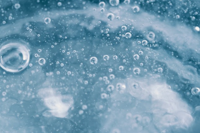 Abstract blue background. The texture of transparent water with bubbles.