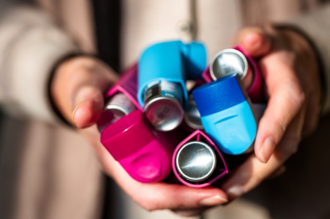 Close up image of asthma inhalers in the hands of a senior woman.