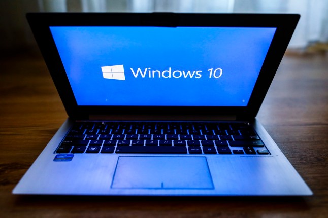 Windows 10 operating system logo is displayed on a laptop screen which is about to be closed.