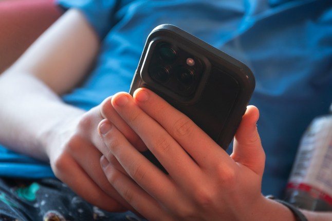 BATH, UNITED KINGDOM - NOVEMBER 30: A 14-year-old boy looks at a iPhone screen on November 30, 2024 in Bath, England. The Australian Senate passed a law to ban children under 16 from having social media accounts and social media platforms, including TikTok, Facebook, Snapchat, Reddit, X, formerly Twitter, and Instagram potentially being be fined for preventing children younger than 16 from having social media accounts. (Photo by Anna Barclay/Getty Images)