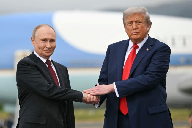 (FILES) US President Donald Trump greets Russian President Vladimir Putin on the tarmac after they arrived at Joint Base Elmendorf-Richardson in Anchorage, Alaska, on August 15, 2025. Hungary's foreign minister said on October 17, 2025 that his country would ensure that Russian President Vladimir Putin can enter and "hold successful talks" with the US despite an ICC arrest warrant against him. Hungarian Prime Minister Viktor Orban and Putin held a phone call on October 17 to discuss the planned US-Russian summit in Budapest. US President Donald Trump, in his latest abrupt pivot on Russia's 2022 invasion of Ukraine, announced he expected to meet Putin in Budapest within two weeks in a fresh bid to reach a peace deal. (Photo by ANDREW CABALLERO-REYNOLDS / AFP) (Photo by ANDREW CABALLERO-REYNOLDS/AFP via Getty Images)