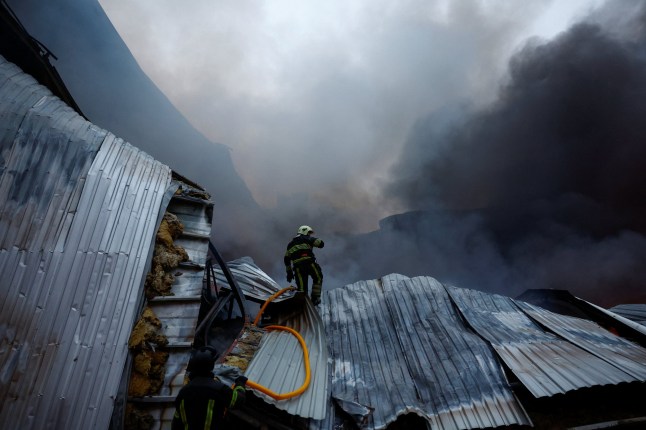 Firefighters work at the site of food warehouses hit by an overnight Russian missile strike