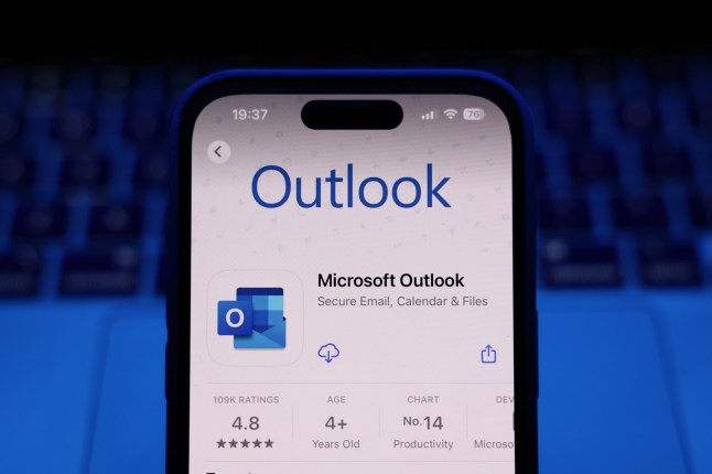 A laptop keyboard and Microsoft Outlook on App Store displayed on a phone screen are seen in this illustration photo taken in Krakow, Poland on March 17, 2025. (Photo by Jakub Porzycki/NurPhoto via Getty Images)