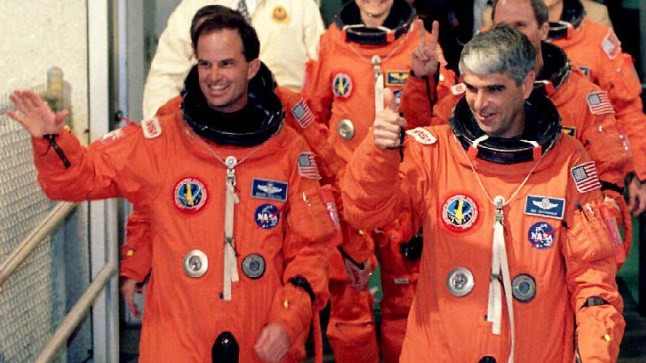 KENNEDY SPACE CENTER, UNITED STATES: Space Shuttle Commander Sid Gutierrez (R) gives the thumbs-up sign 09 April 1994 as he and Pilot Kevin Chilton (L) leave their quarters to board the Space Shuttle Endeavour at the Kennedy Space Center, Florida, for their flight. Endeavour and its six-person crew are scheduled for a nine-day mission. (Photo credit should read BOB PEARSON/AFP via Getty Images)