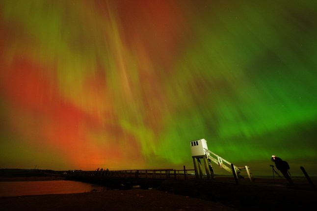 The Northern Lights, also known as the Aurora Borealis, seen in an incredible display in the skies over the refuge hut on the causeway leading to Holy Island in Northumberland, on the North East coast of England, in the early hours or Friday morning. Aurora displays occur when charged particles collide with gases in the Earth's atmosphere around the magnetic poles. As they collide, light is emitted at various wavelengths, creating colourful displays in the sky. Picture date: Friday October 11, 2024. PA Photo. See PA story WEATHER NorthernLights. Photo credit should read: Owen Humphreys/PA Wire