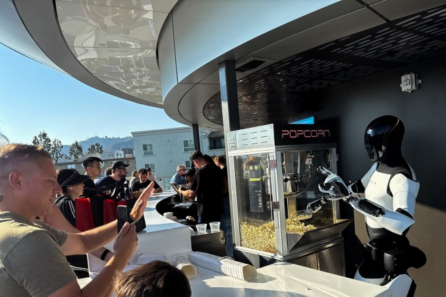 A Tesla Optimus robot scoops popcorn and gestures at attendees during the opening of the Tesla Diner and Drive-In restaurant and Supercharger on Santa Monica Blvd in the Hollywood neighborhood Los Angeles, California on July 21, 2025. Elon Musk's electric vehicle company Tesla has opened a diner on Santa Monica Boulevard in Los Angeles. (Photo by Patrick T. Fallon / AFP) (Photo by PATRICK T. FALLON/AFP via Getty Images)