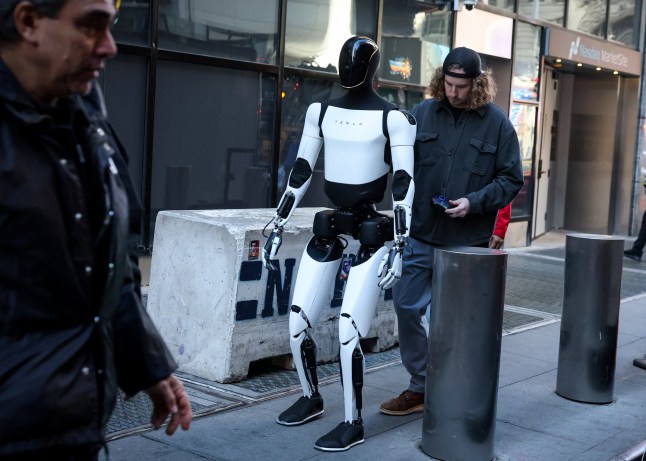 A Tesla Optimus robot walks during an appearance outside the Nasdaq Market site in New York City, U.S., October 27, 2025. REUTERS/Brendan McDermid