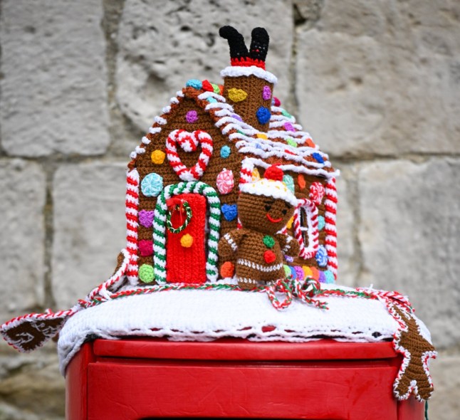 WEYMOUTH, ENGLAND - DECEMBER 20: Festive Christmas knitted decoration topper is seen on a post box, on December 20, 2023 in Weymouth, United Kingdom. (Photo by Finnbarr Webster/Getty Images)